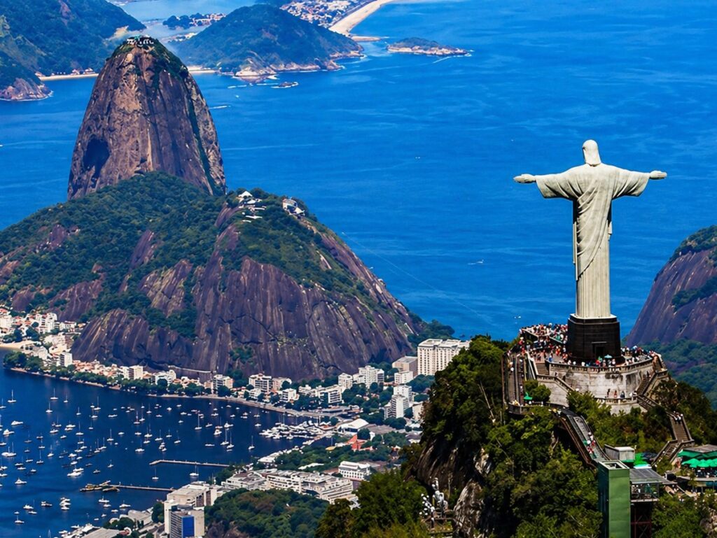 Vista panorâmica do Cristo Redentor no topo do Corcovado com o Pão de Açúcar ao fundo.