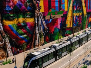Grafite do Mural Etnias de Eduardo Kobra no Boulevard Olímpico com o VLT passando