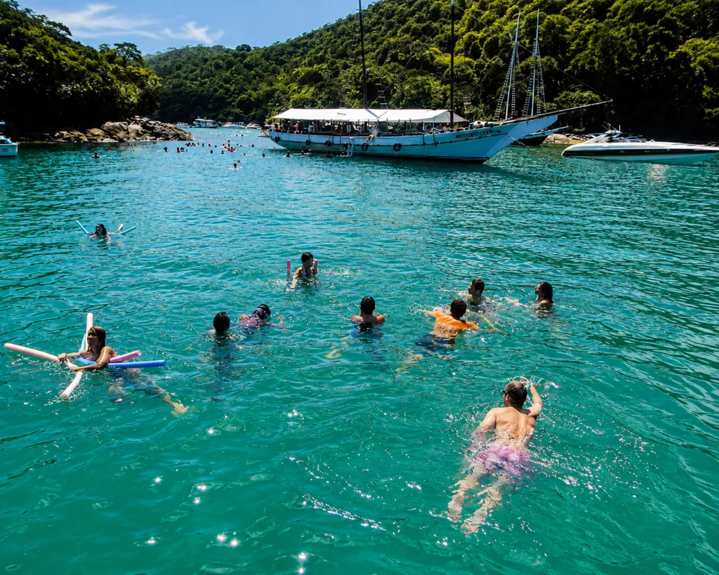 Turistas aproveitando uma parada para banho em águas cristalinas durante o passeio para Angra dos Reis saindo do Rio de Janeiro com a Guia Rio Tur.