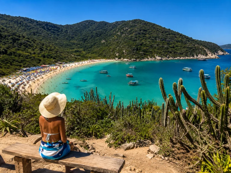 Vista panorâmica da Praia do Forno em Arraial do Cabo com águas cristalinas, areia branca e vegetação preservada.