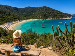 Praia do Forno em Arraial do Cabo cercada por natureza e mar cristalino durante o passeio saindo do Rio de Janeiro.